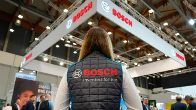Person at a Bosch stand at a fair or event, showcasing PCB manufacturing service copperdot.